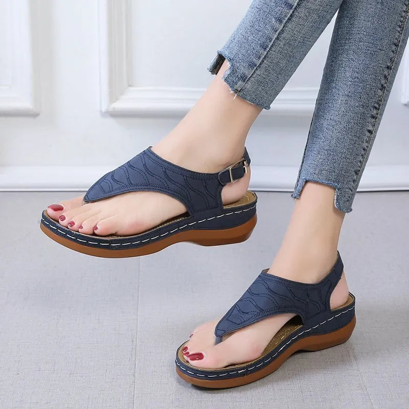 Women's red wedge heel flip flop sandals with an adjustable buckle strap on a white background.