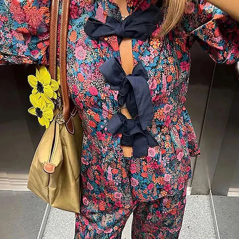 Women's floral print trousers suit with a tie-neck puff sleeve top and matching trousers