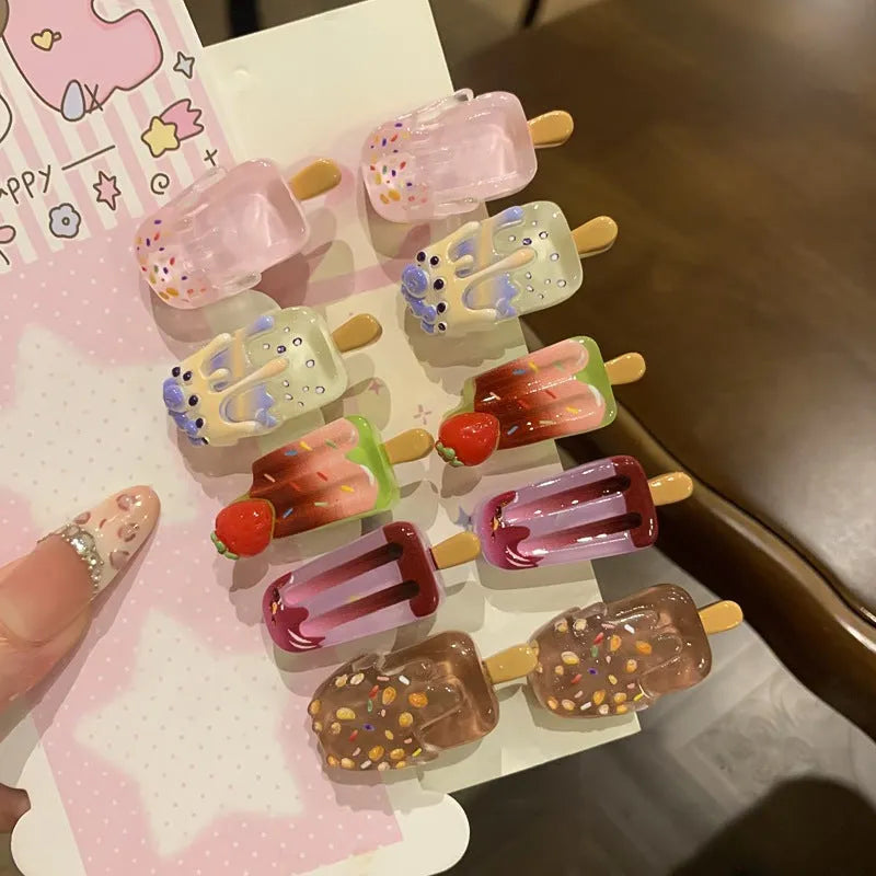 A resin hair clip shaped and coloured like a cartoon ice cream barrette, shown on a side clip.