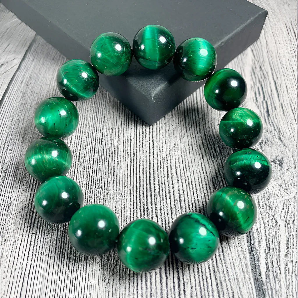 A natural green tiger eye stone bracelet with polished geometric beads on a wrist.