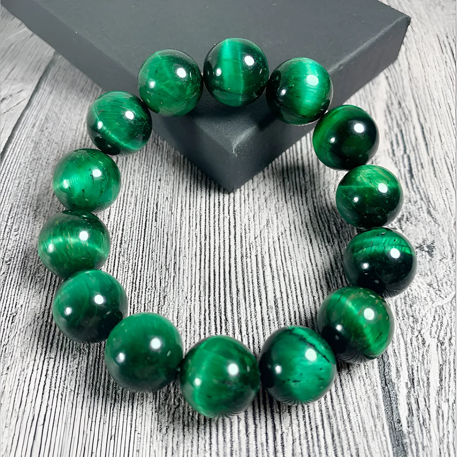 A natural green tiger eye stone bracelet with polished geometric beads on a wrist.