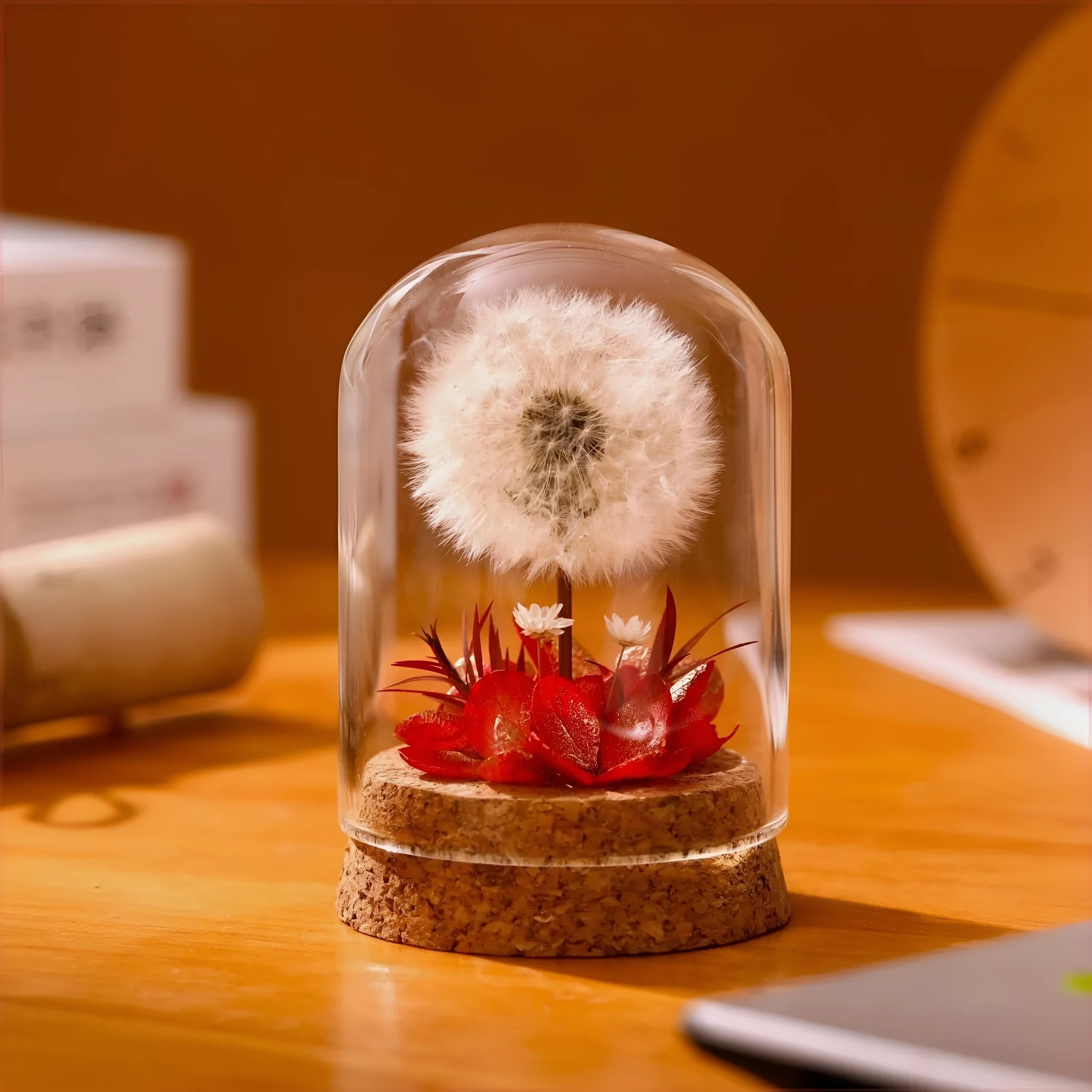 Dandelion-shaped glass night light ornament in gradient colours on wooden surface