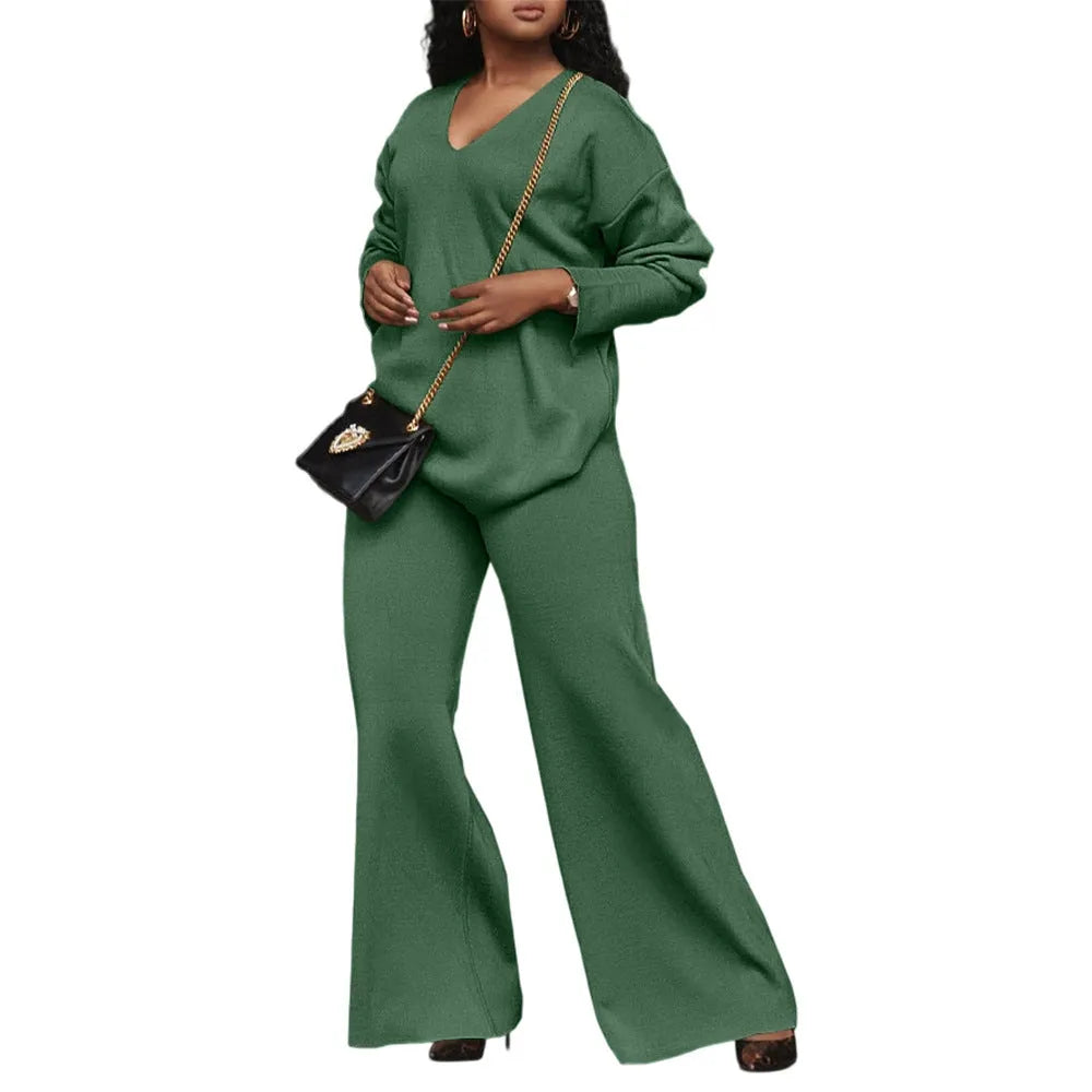 Brown women's suede two-piece suit with split sleeves and matching trousers on a hanger.