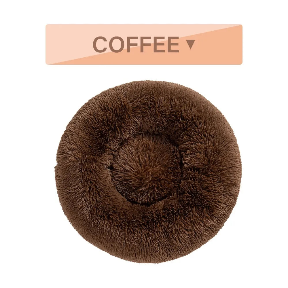 Fluffy donut-shaped dog bed in light grey plush material, showing raised rim and central cushion.