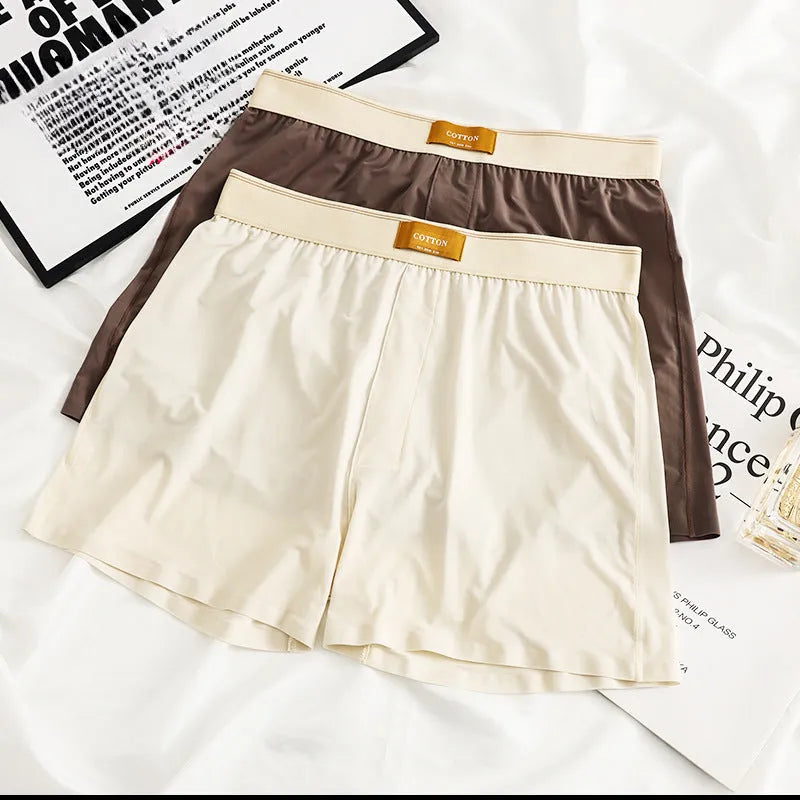 Men's solid colour loose ice silk underwear in beige apricot, laid flat.