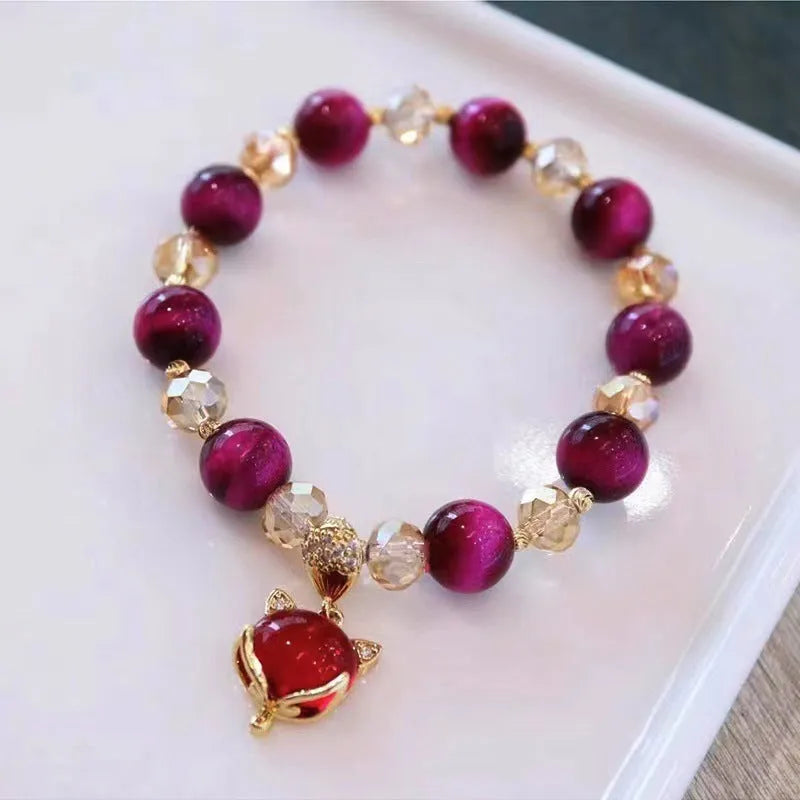 Handmade Tigereye stone bracelet with animal charm clasp on wrist, showing single and double chain styles in green and rose red.