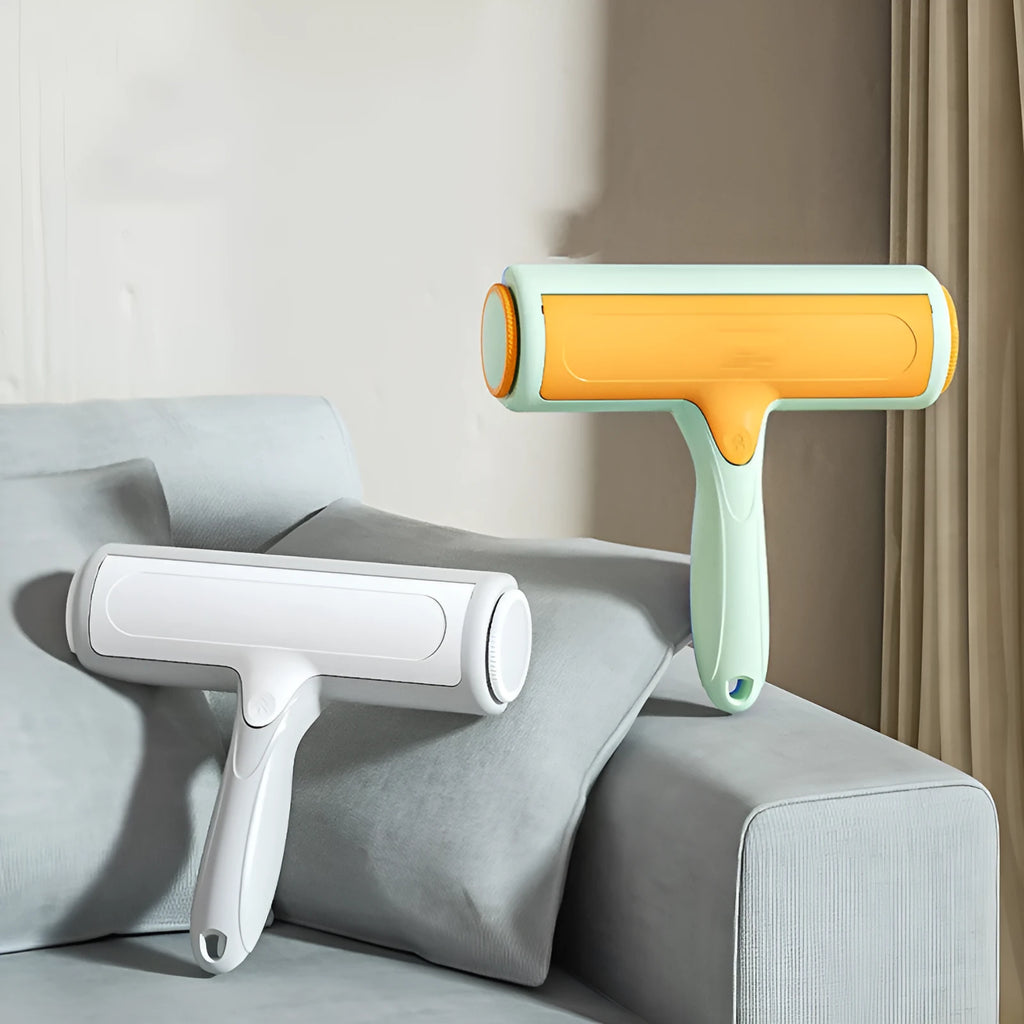 Two-way roller pet hair removal brush in green orange colour with ABS body and nylon fibre bristles on a beige sofa