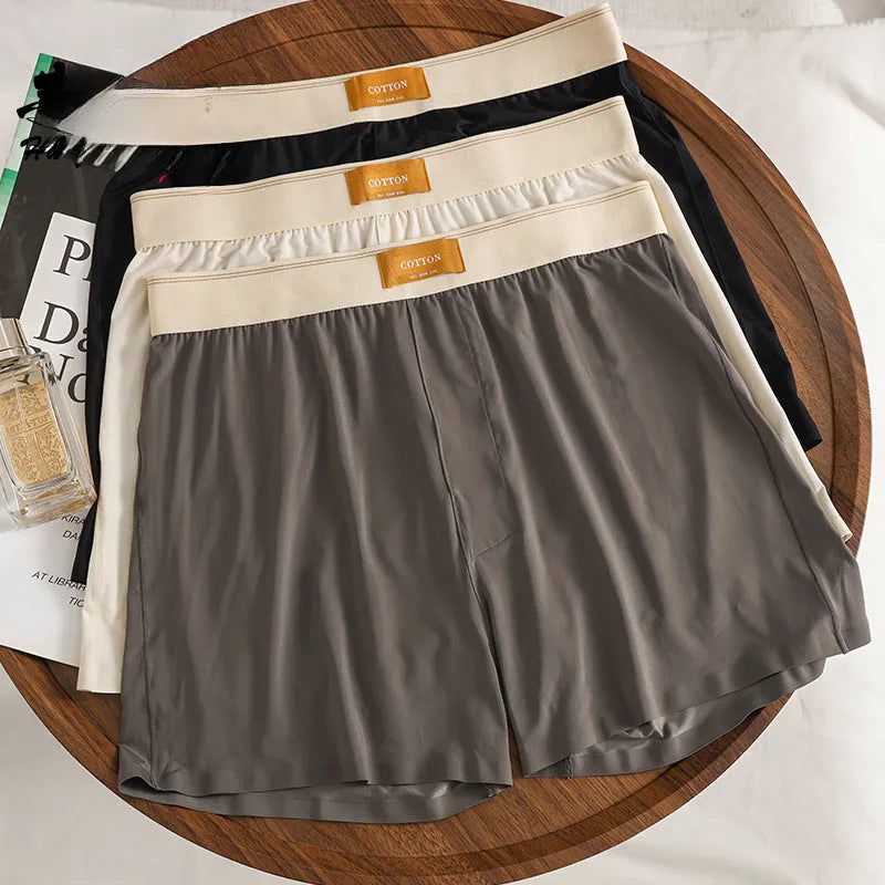 Men's solid colour loose ice silk underwear in beige apricot, laid flat.