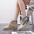 Women's high-top canvas short boots with cross straps and buckles in black, side view