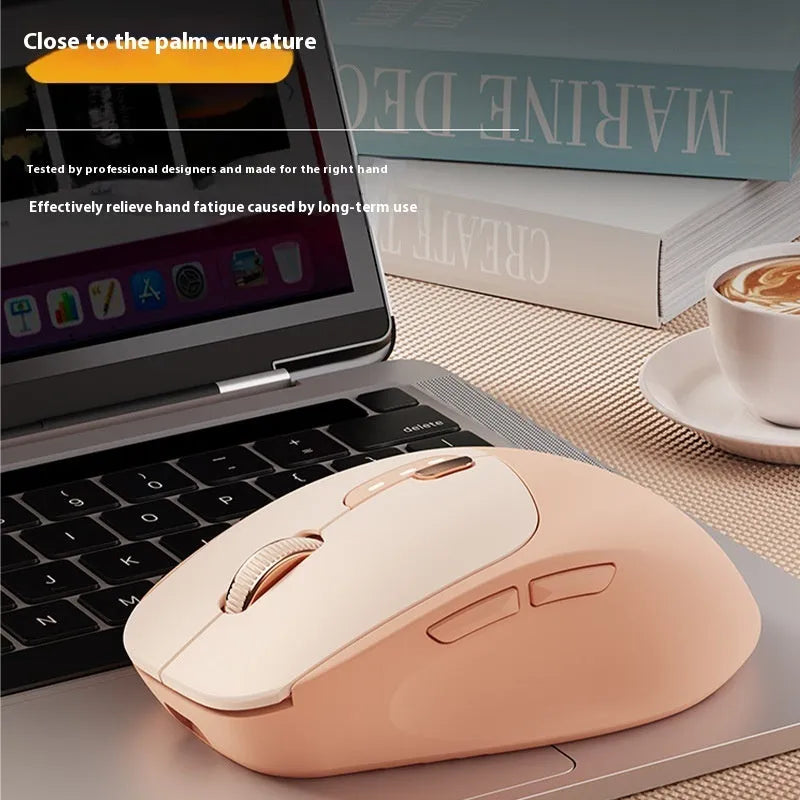 A mute wireless Bluetooth mouse in Matcha Green colour on a desk, showing its compact size and five-button layout.