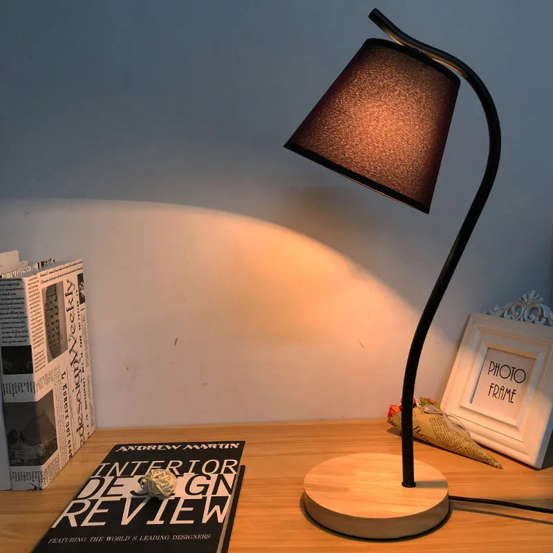 A modern LED table lamp with a push button dimmer switch on its base.