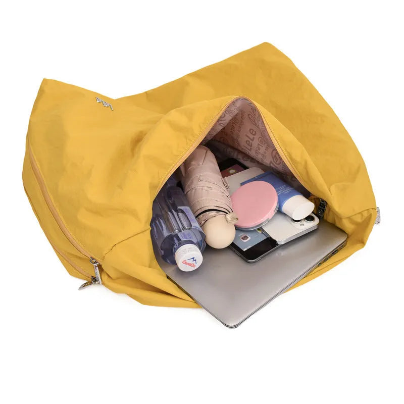 Soft heart-shaped nylon underarm bag for women in yellow, shown worn crossbody.