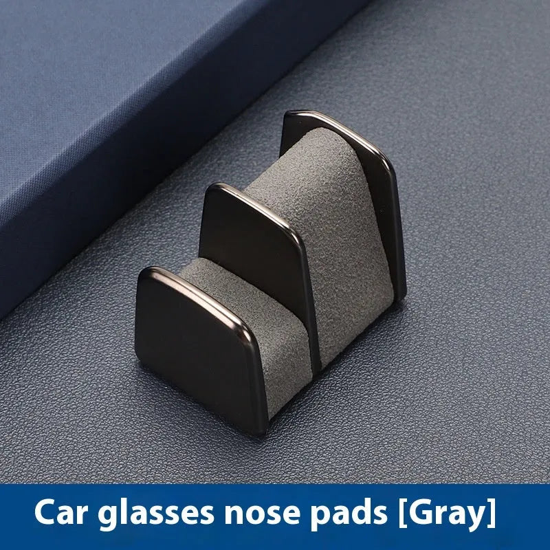 Zinc alloy and leather car dashboard clip for holding sunglasses, shown in green colour.