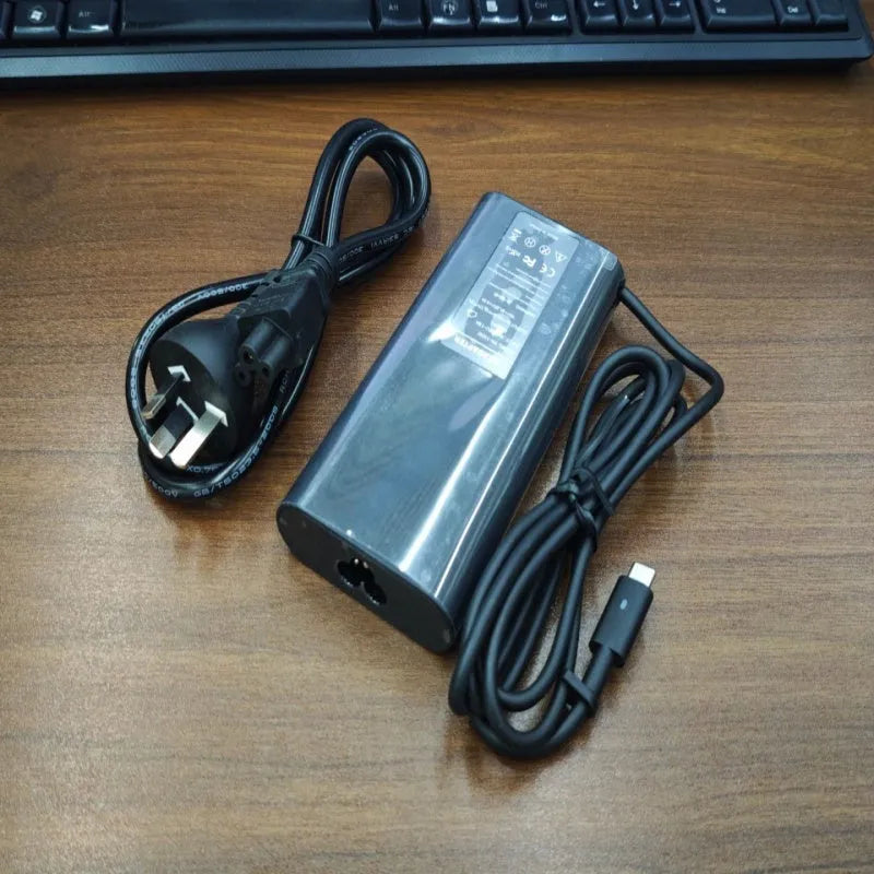 Black oval 65W Type-C laptop power adapter with multiple international plug configurations
