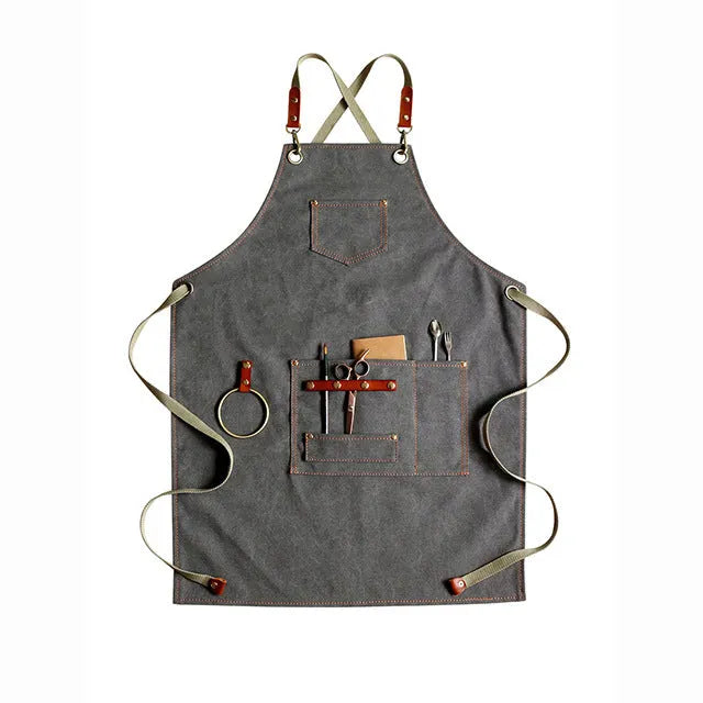 Canvas apron with cross-back straps in camel colour.
