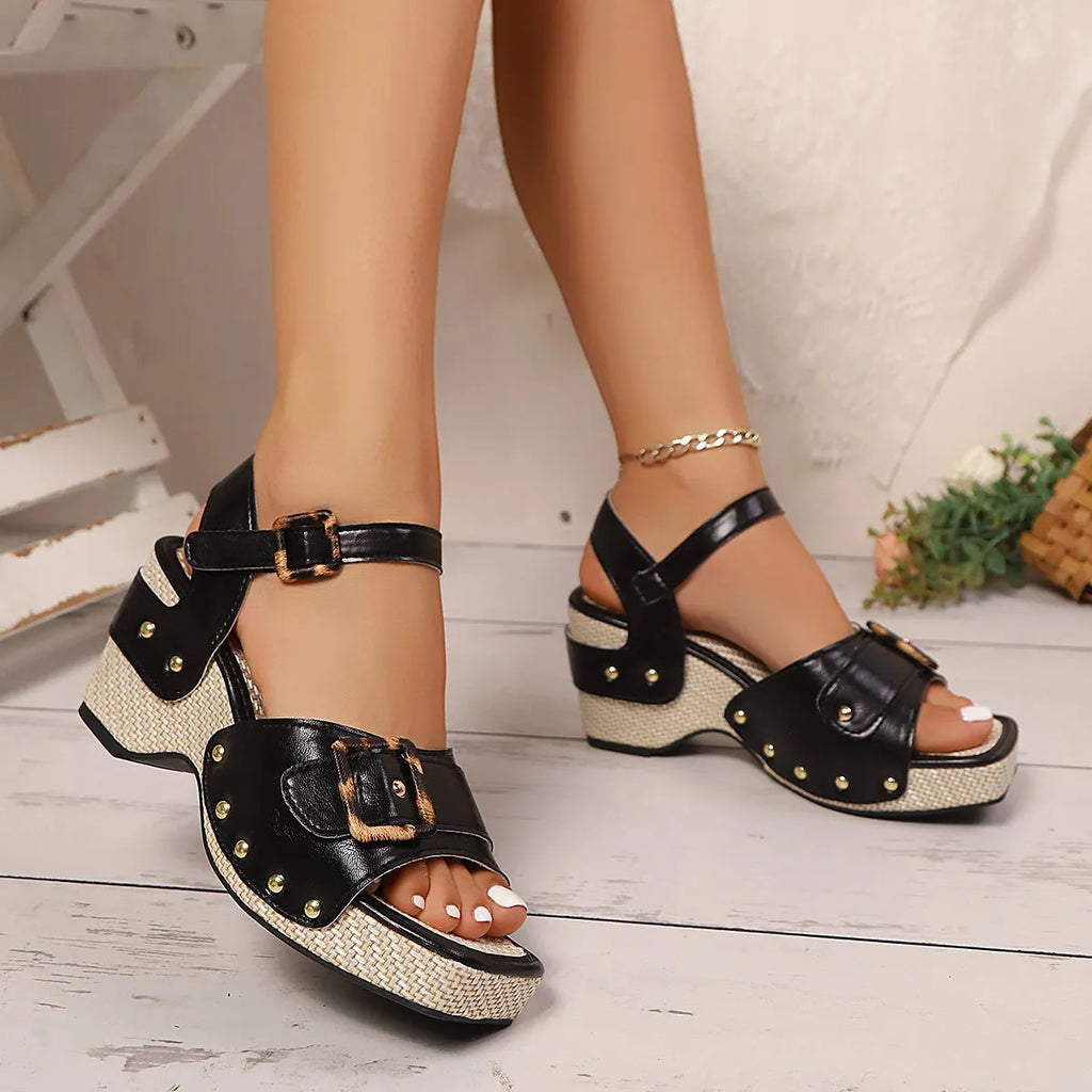 Women's black square toe sandals with a chunky heel and metal buckle on a white background.