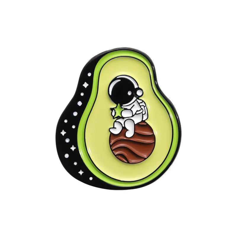 Colourful cartoon fruit design metal letter brooch on a fabric background.