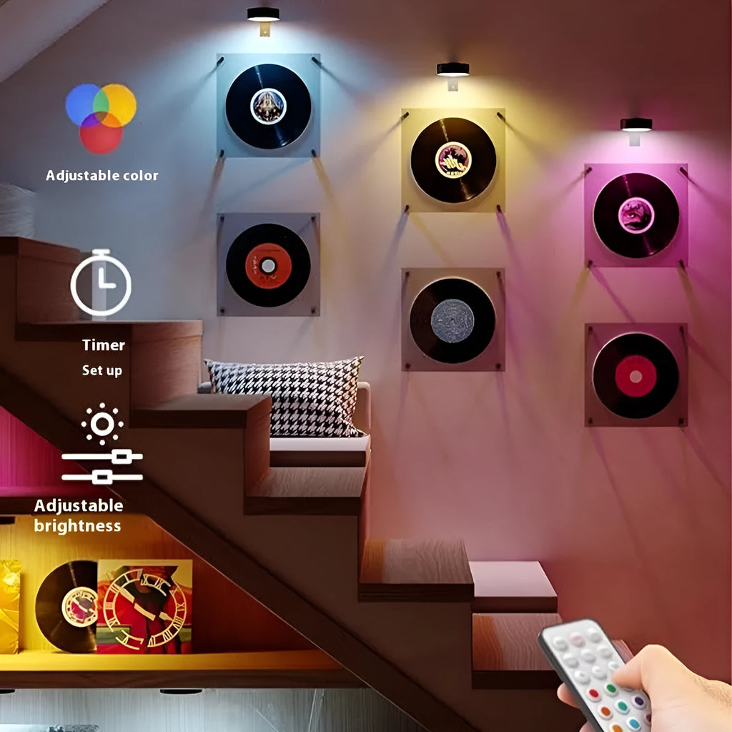 Magnetic LED light bars mounted around a painting, with a remote control on a table nearby.