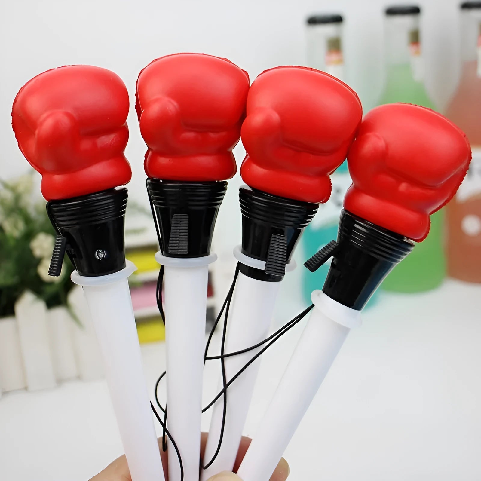 Four black boxing press ejection pens with a bullet-shaped 0.7mm tip on a desk.
