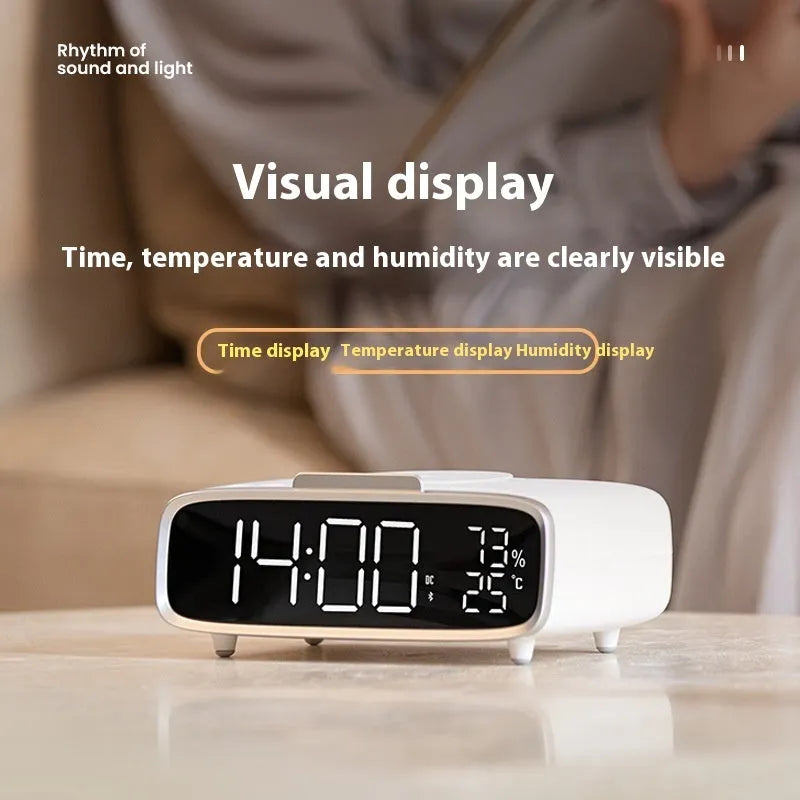 White wireless charging Bluetooth speaker alarm clock with LED night light on bedside table