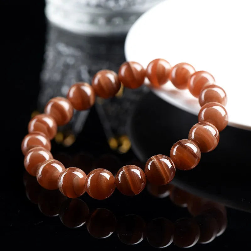 Natural old mine rhodochrosite round bead bracelet with ruyi detail, shown in 6mm and 8mm size options.