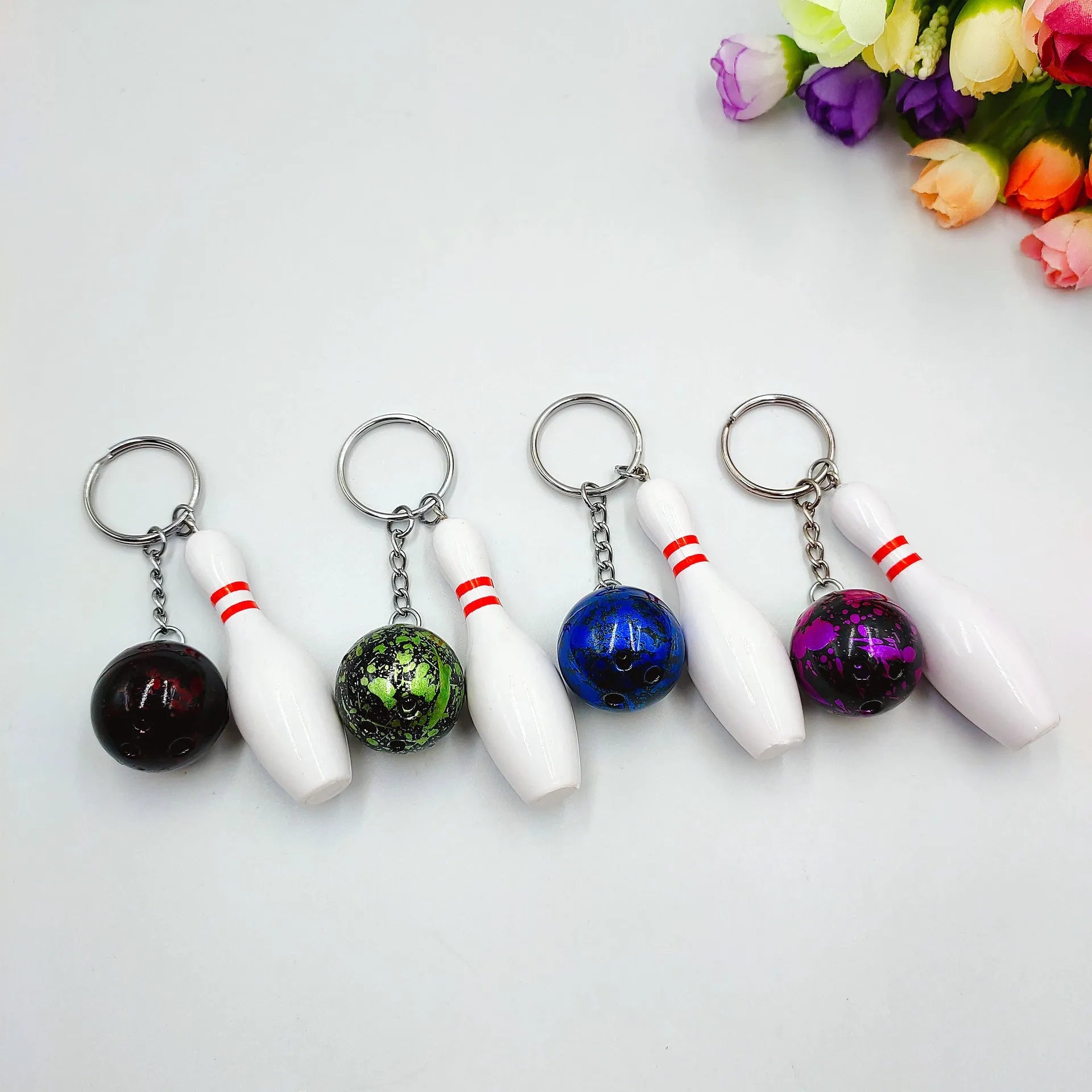 Mini simulation bowling ball keychain pendant in dark red, blue, purple, and green colour options.