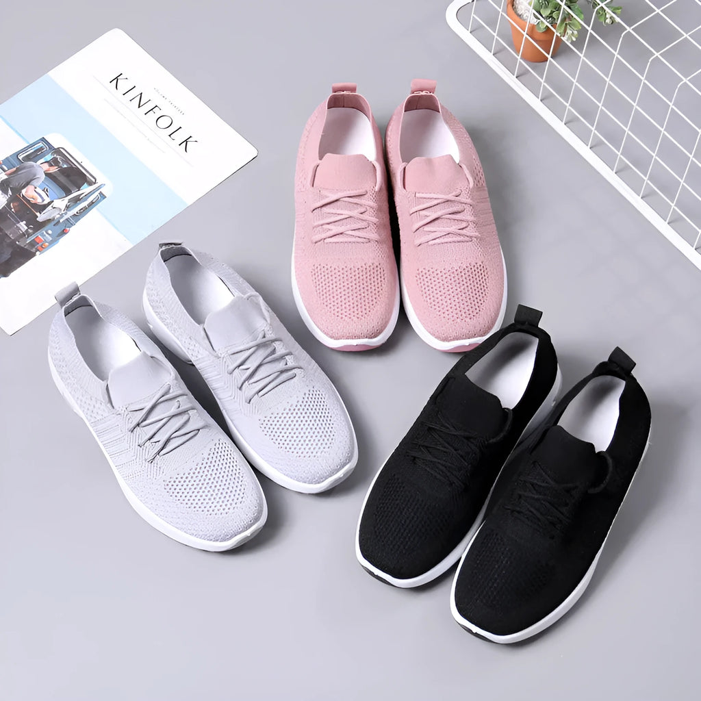 Women's black mesh casual sneakers with round toe and lace-up front on a grey background.