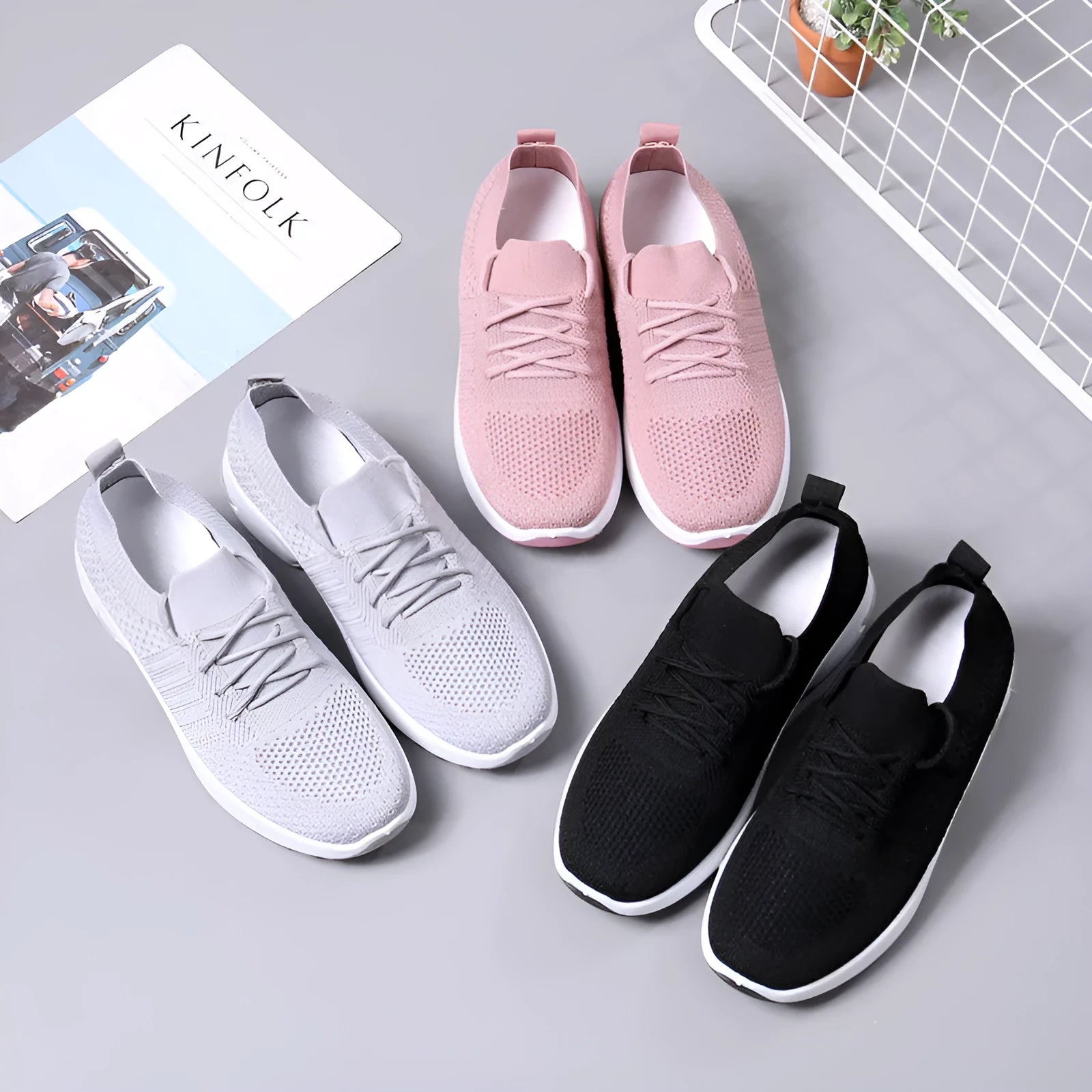 Women's black mesh casual sneakers with round toe and lace-up front on a grey background.