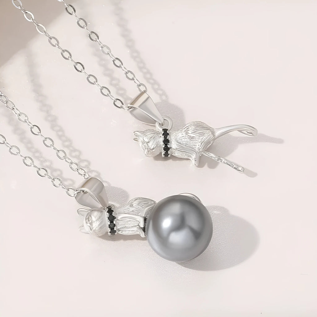 Close-up of a sterling silver cat pendant necklace on a clavicle, showing the electroplated finish.