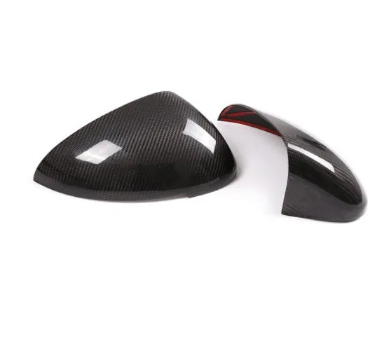 Pair of black true carbon fibre rearview mirror covers for Porsche Macan, showing textured weave pattern.