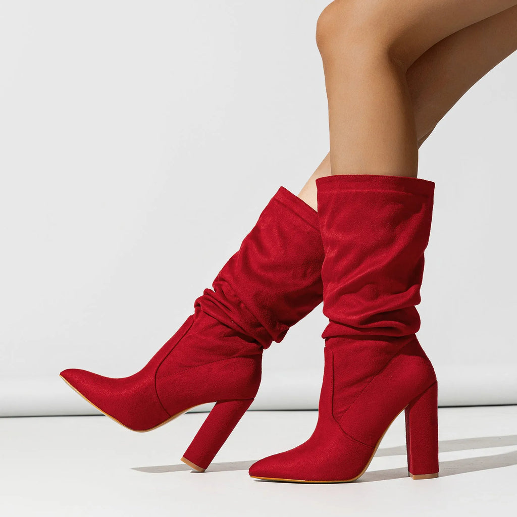 Black suede women's ankle boots with a chunky high heel and pointed toe on a neutral background.