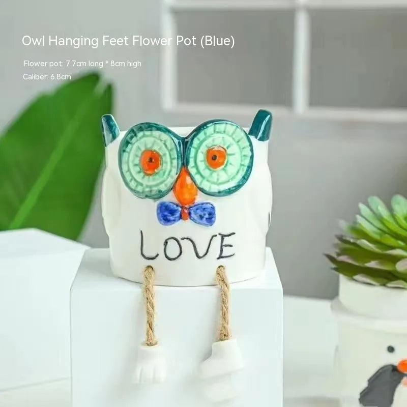 Ceramic hanging foot flowerpot in a cartoon style, shown on a desktop with a small succulent plant.