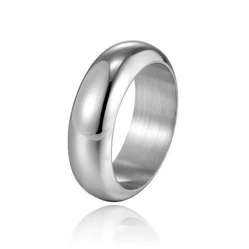 Glossy electroplated titanium steel ring in gold, black, and steel colours on a jewellery background.
