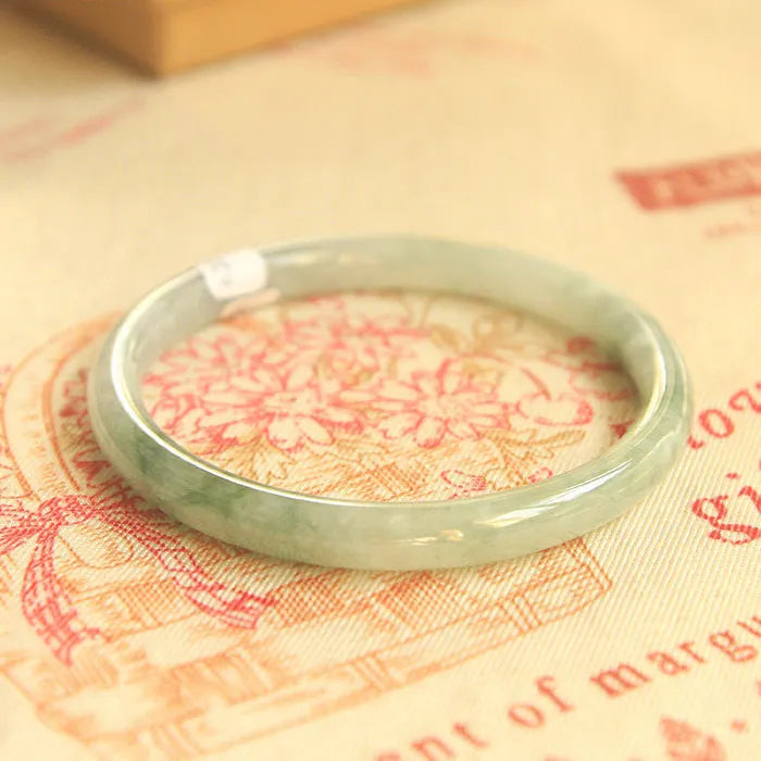 Green jade waxy student bracelet with geometric Chinese design showing adjustable sizing options