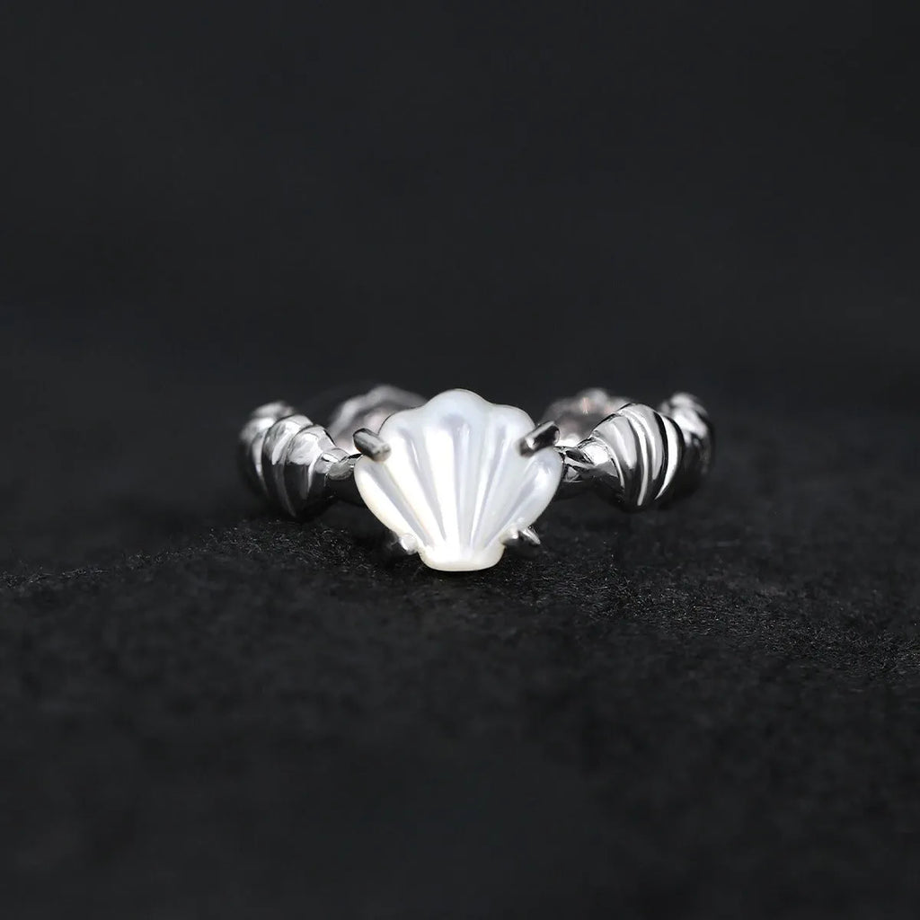 Adjustable silver ring featuring a carved shell and tiger eye stone design in a choice of finishes.