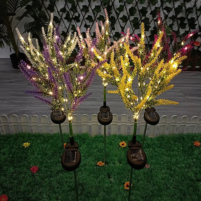 74cm tall solar-powered lavender-shaped LED garden light with stainless steel stem in a flower bed.