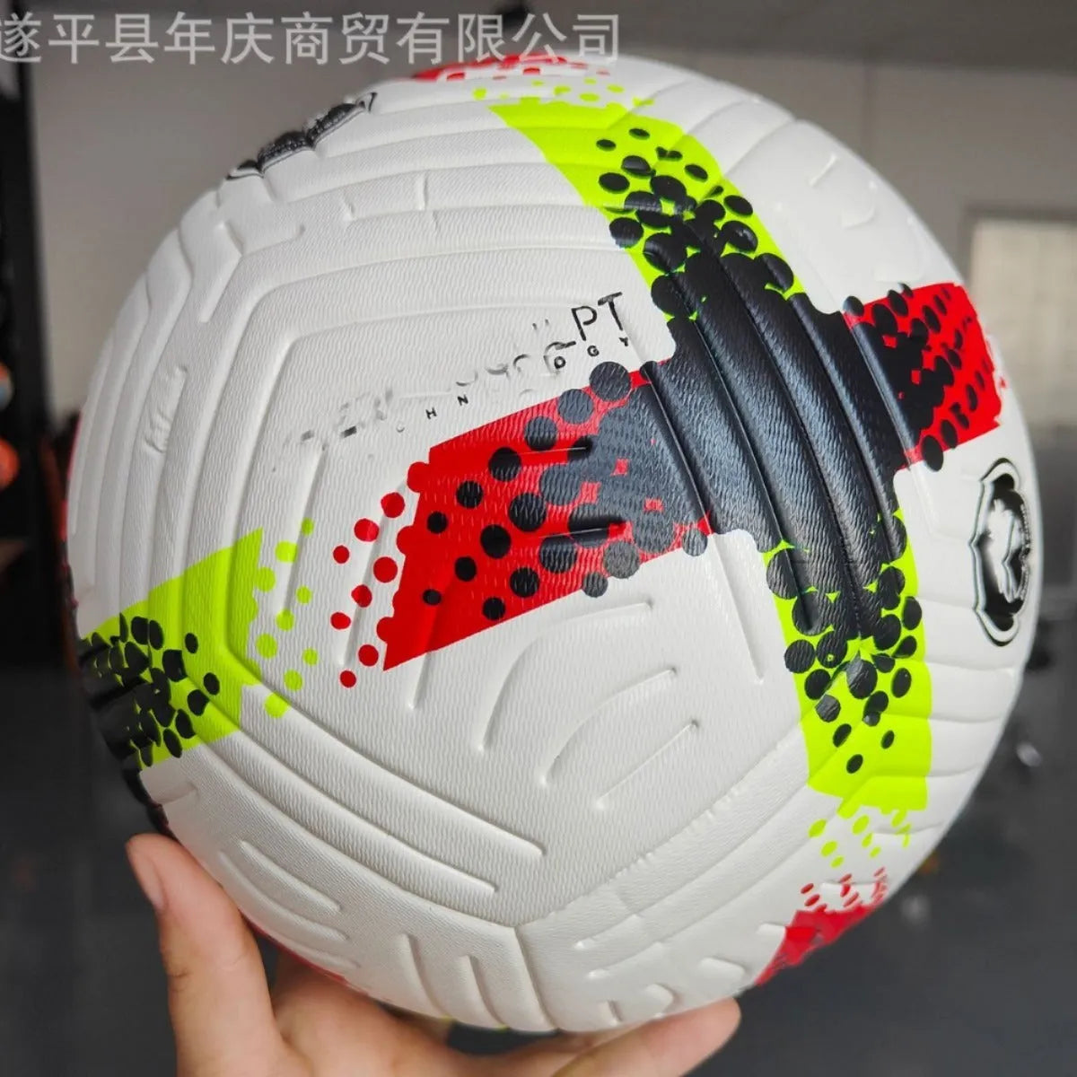 Fluorescent green official Size 5 football with seamless thermal adhesive patch PU construction on a training pitch.