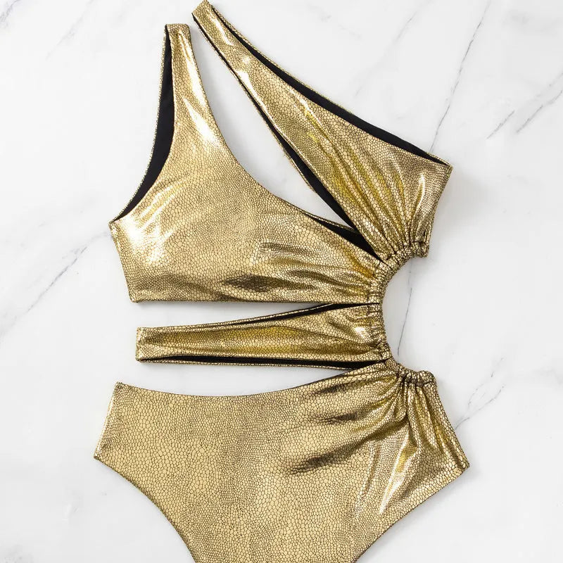 Women's gold backless one-piece swimsuit on a model, showing spandex material and solid colour design.