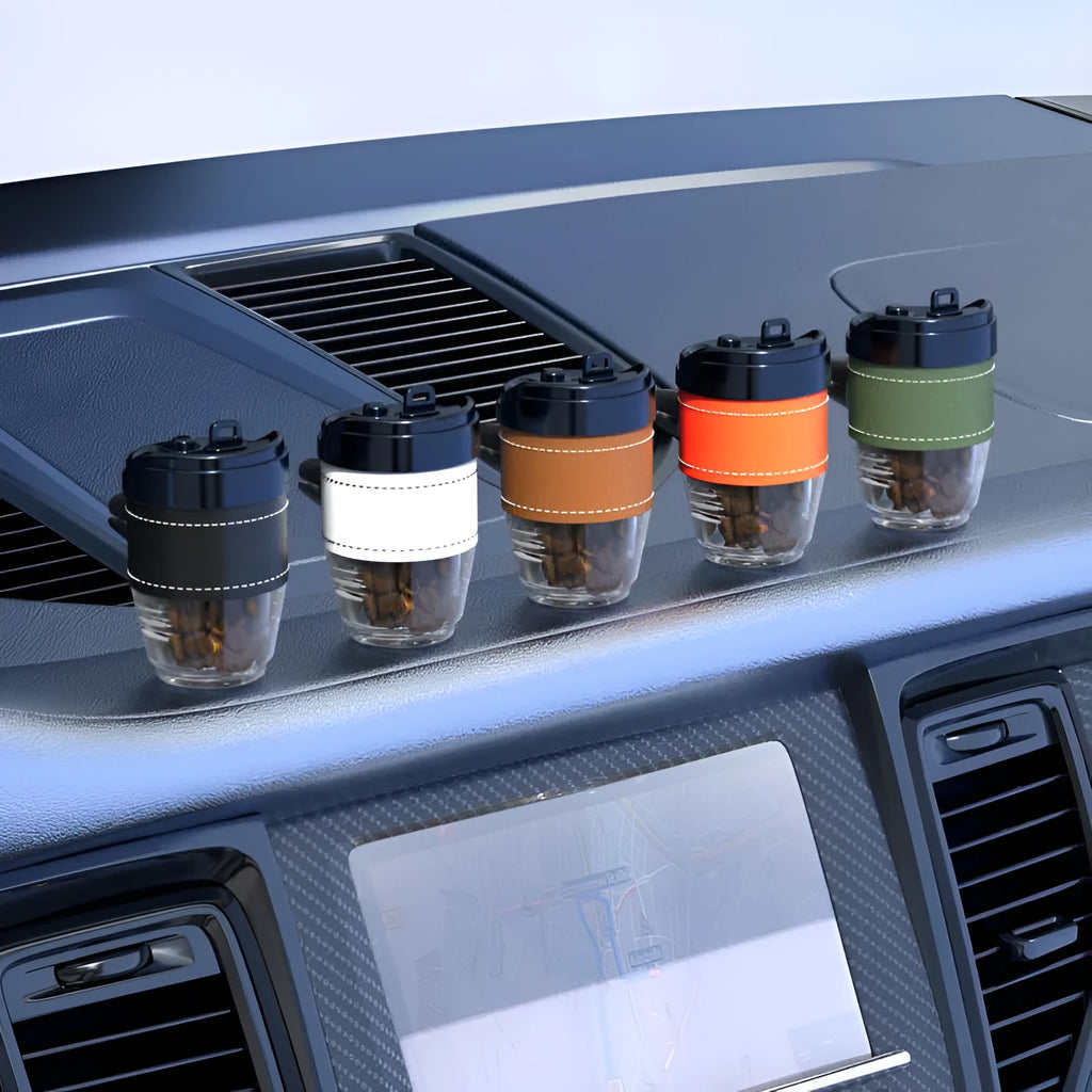 Coffee cup shaped solid car air freshener in black, brown, white, orange, and green colours.