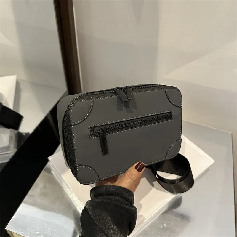 A dark grey women's square crossbody bag made of PU leather, shown with a single shoulder strap and visible sewing line detail.