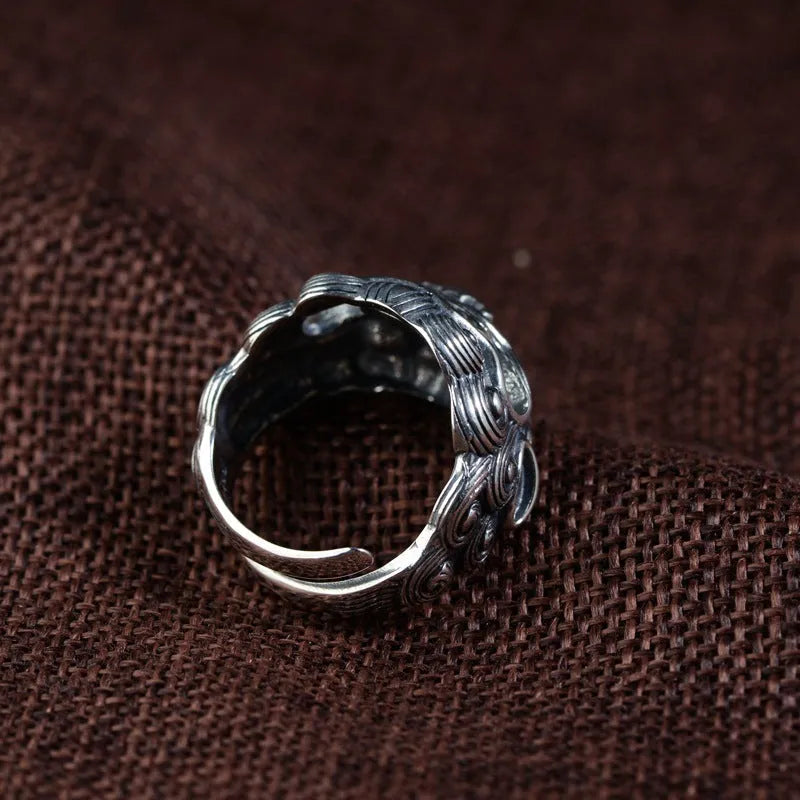 Silver open ring with detailed Jibeast and zodiac animal pattern, shown on a hand.