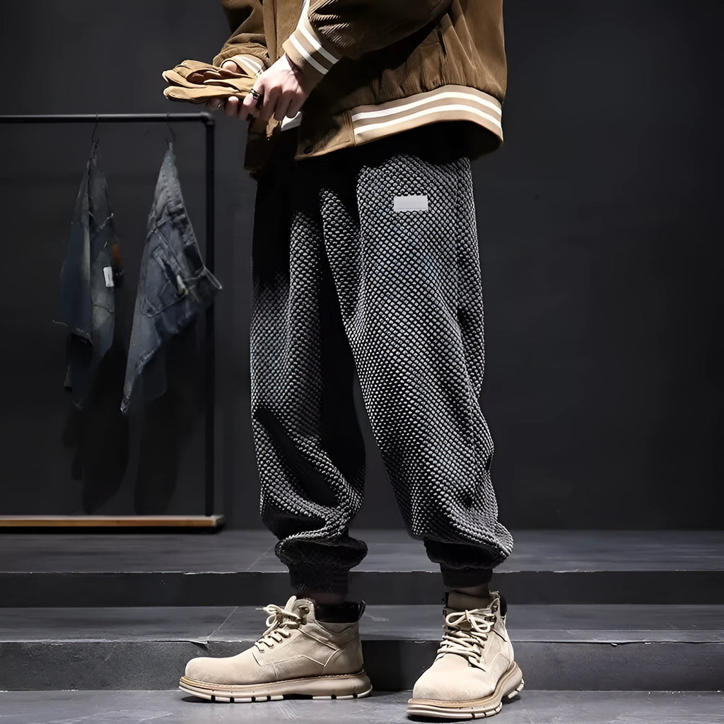 Men's grey straight leg sweatpants with ankle strap detail on a plain background.