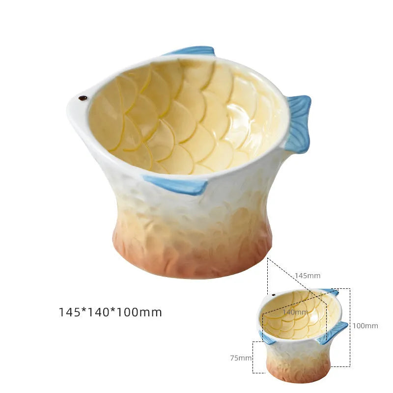 Blue fish-shaped ceramic cat bowl with tilted design and non-slip base on a wooden surface.