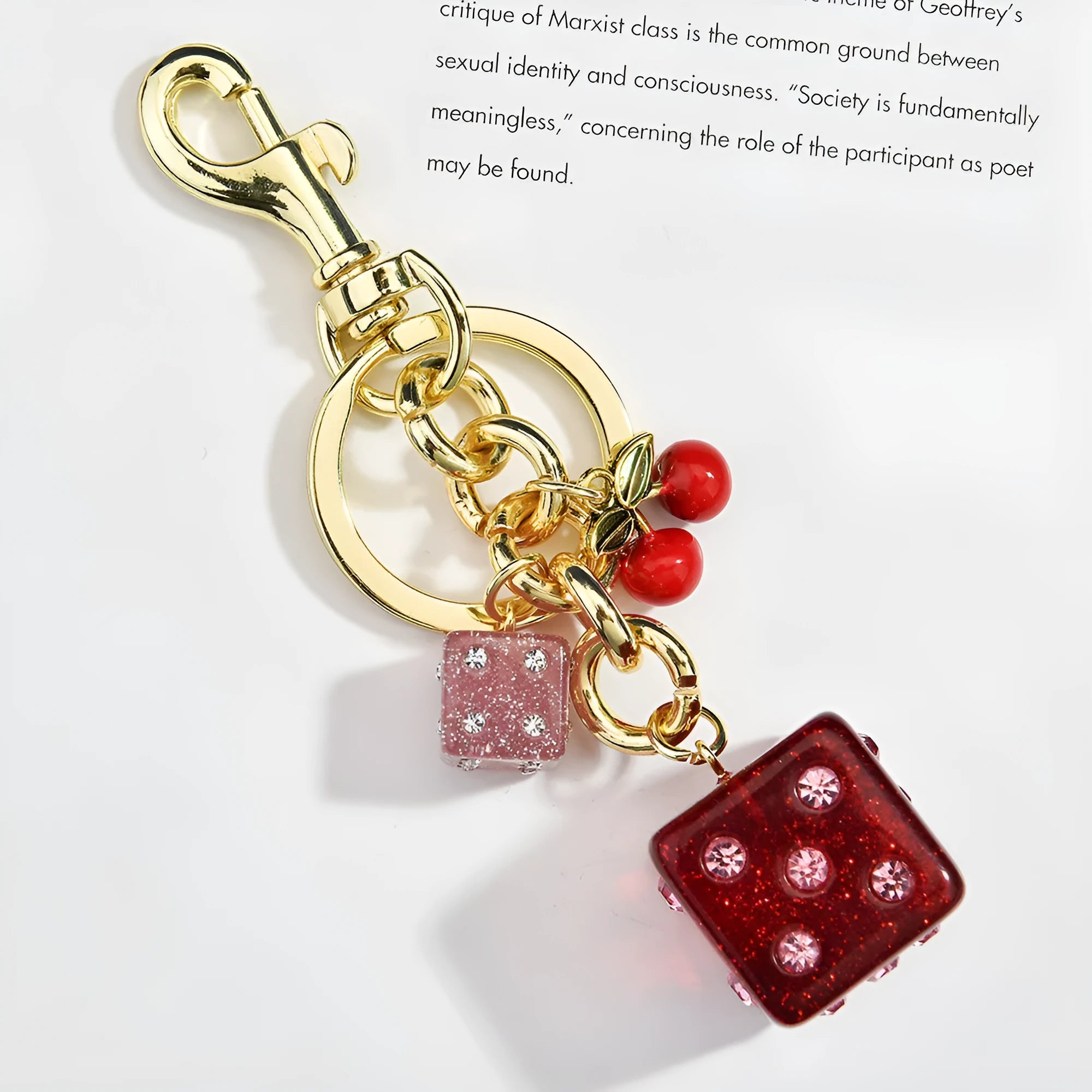 Close-up of a cherry red and white metal dice keychain pendant with a square pattern on a vintage-style suitcase charm.