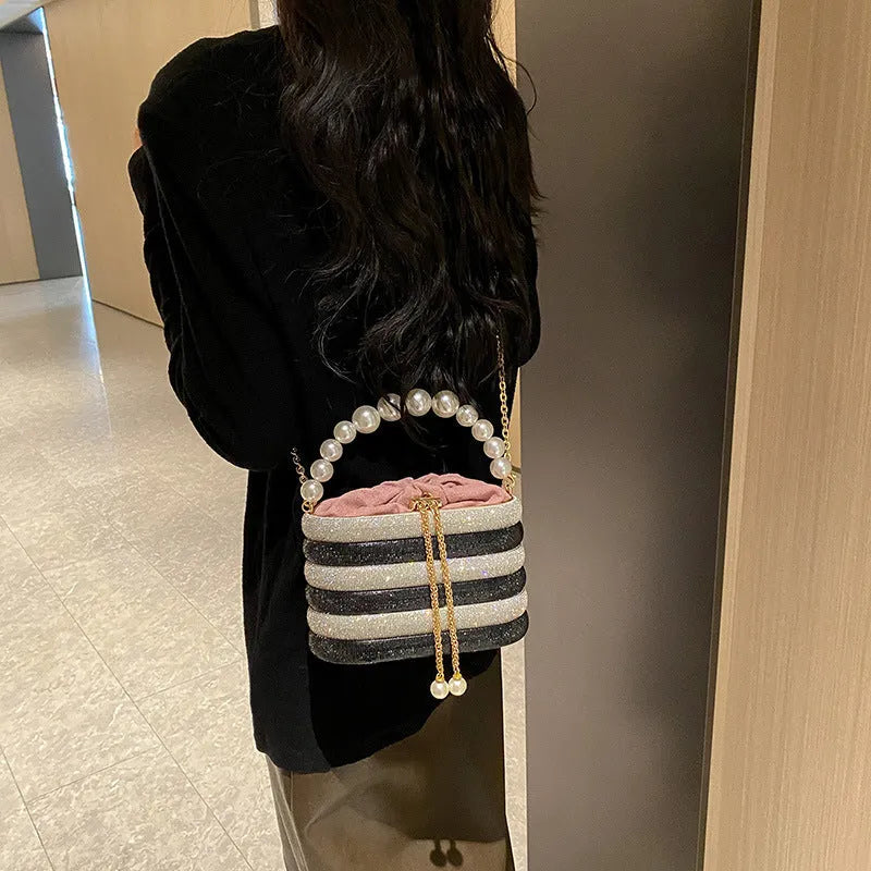 Women's black one-shoulder crossbody bag with pearl beading on the front.