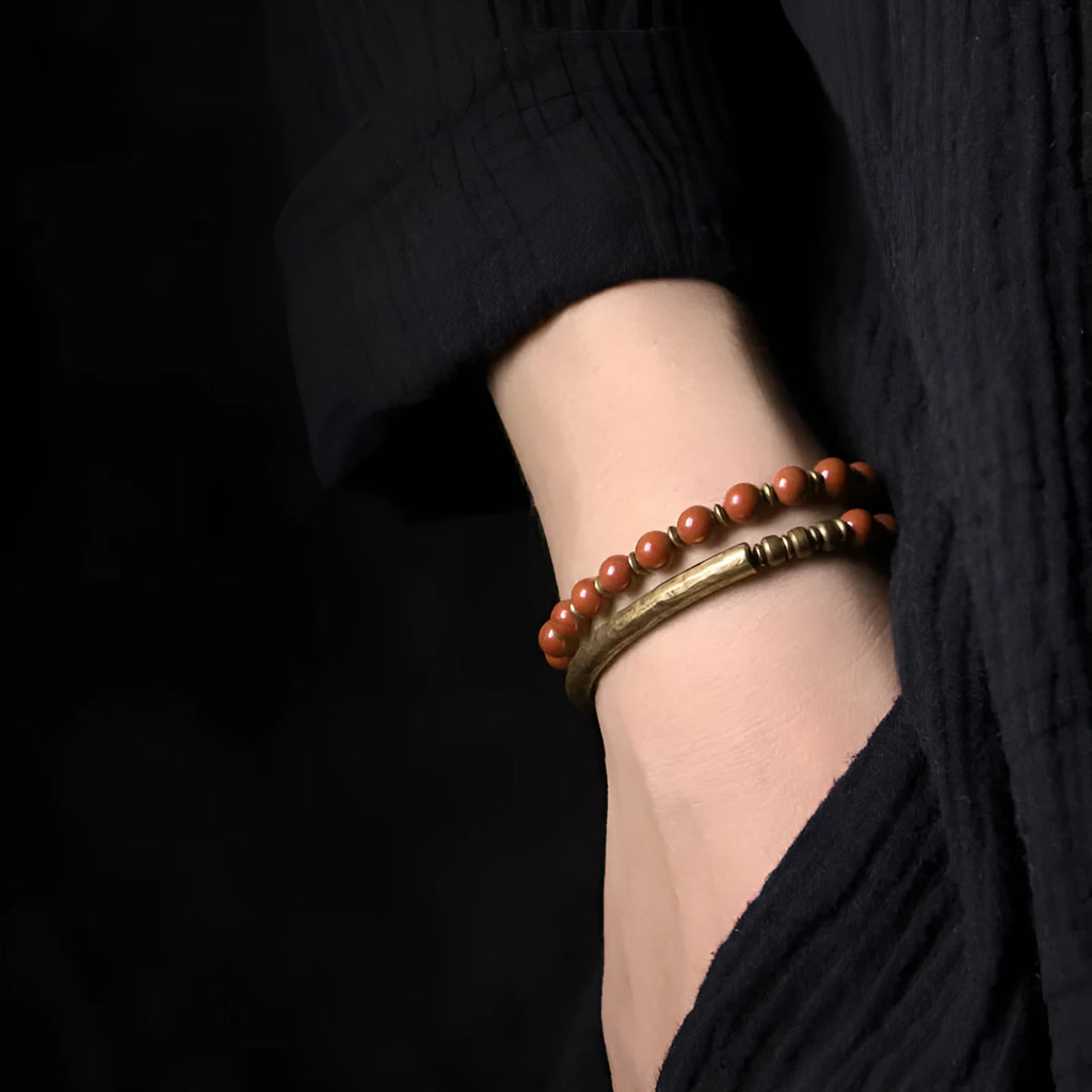 Layered ethnic bracelet with natural stones and brass components on a wrist