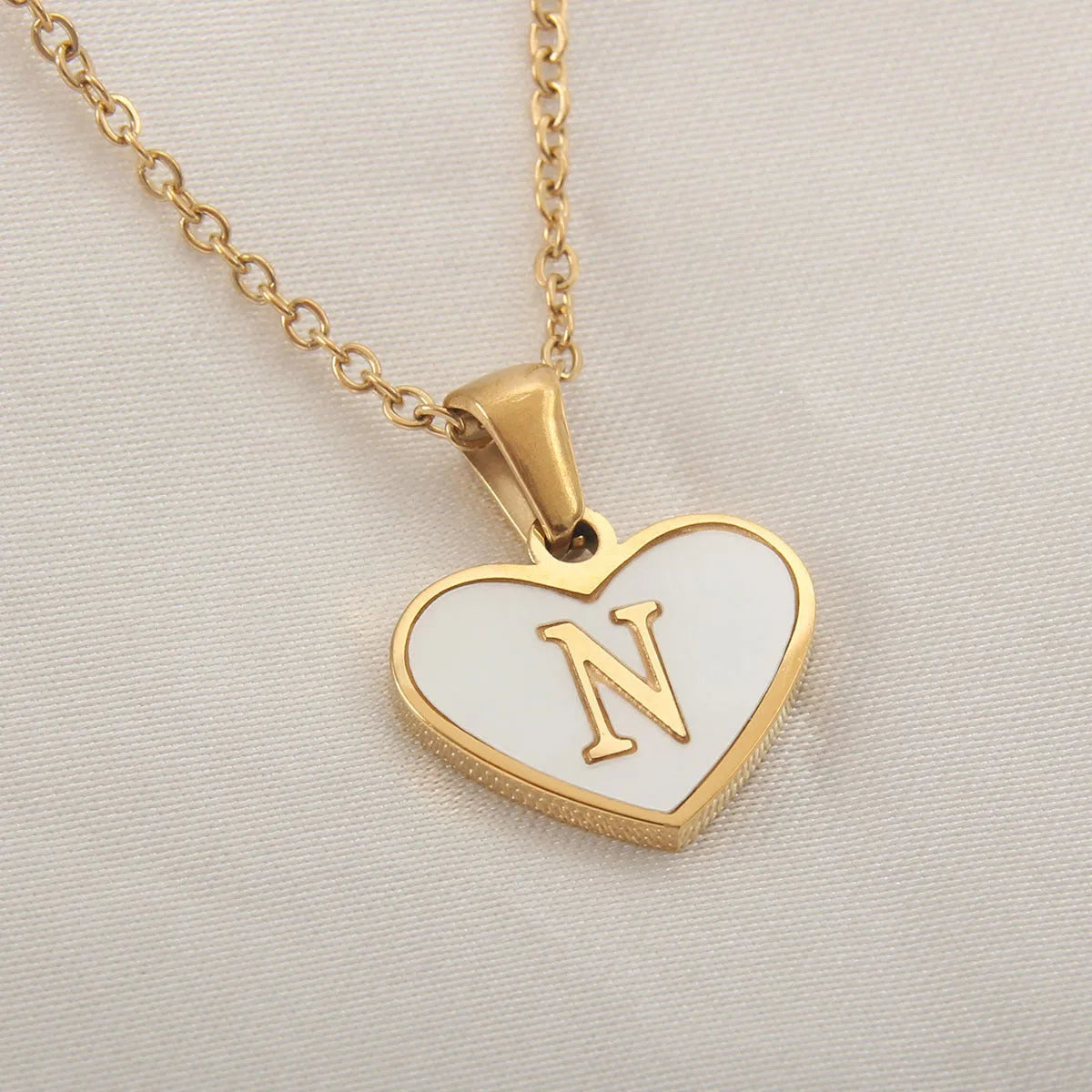 Gold plated chain necklace with a white shell heart-shaped pendant personalised with a single letter initial.