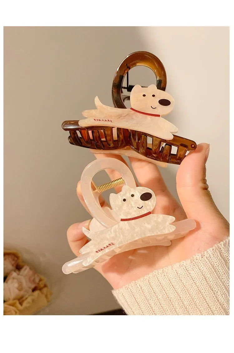 Cartoon puppy design hair barrette clip in beige and brown colours on a white background.