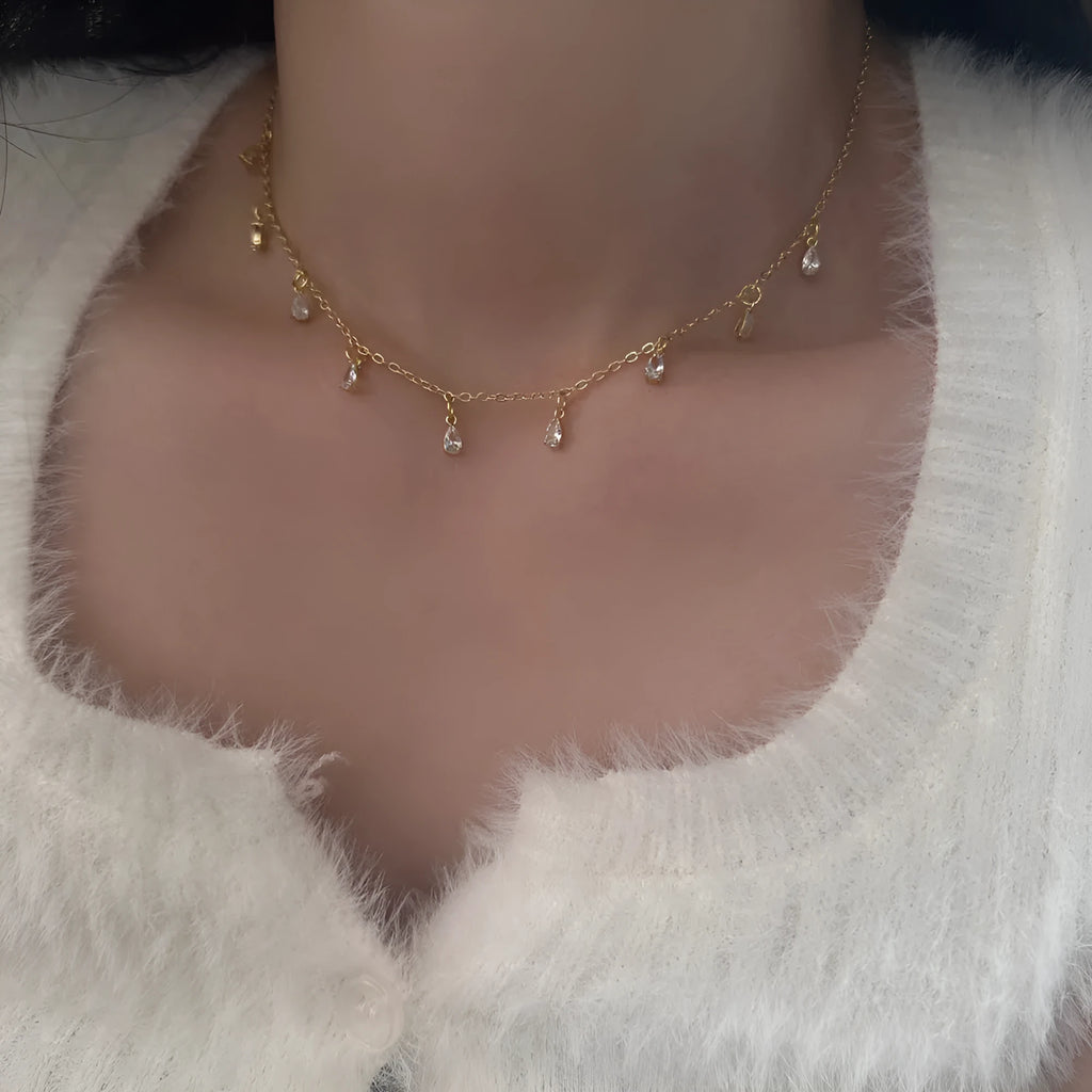 Zircon three-piece jewellery set with geometric meteor shower pendant necklace, matching earrings, and anklet.