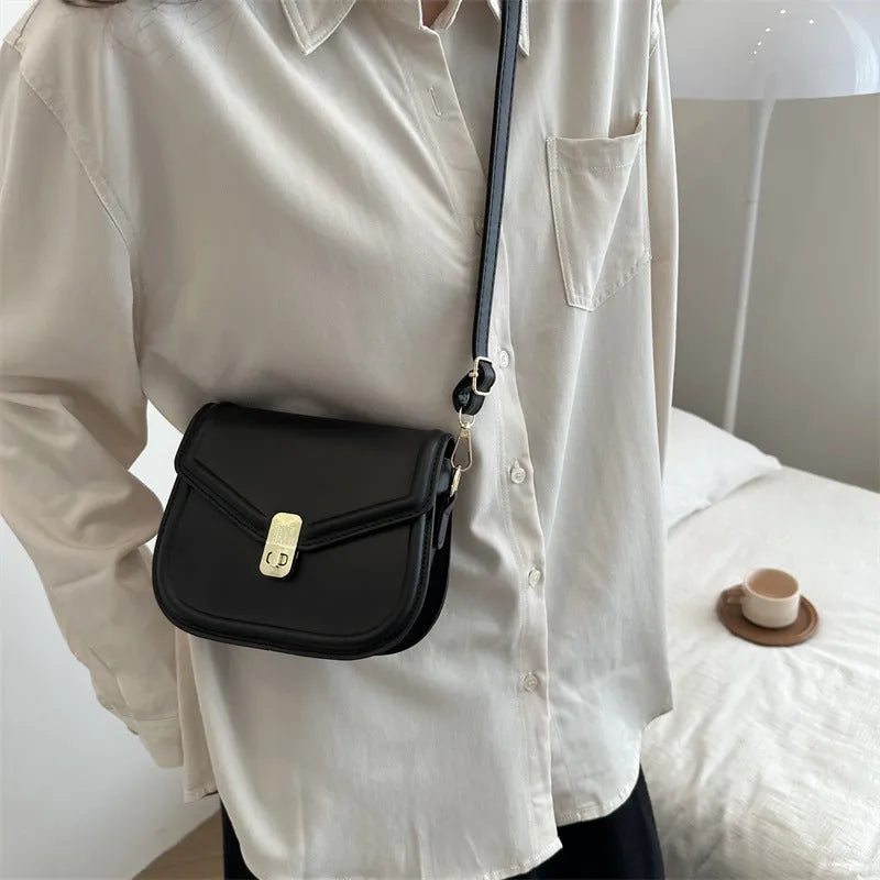 Soft PU leather clamshell shoulder messenger bag in horizontal square shape on adjustable strap.